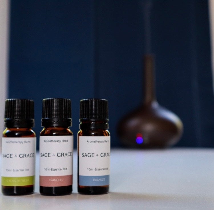 Three bottles of essential oil blends in front of an electronic diffuser