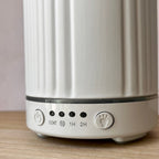 Close-up of a white ribbed cylindrical electric diffuser 