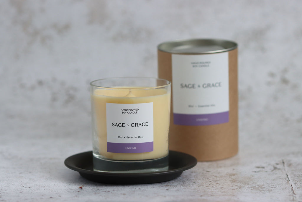 Unwind essential oil candle infront of tube packaging